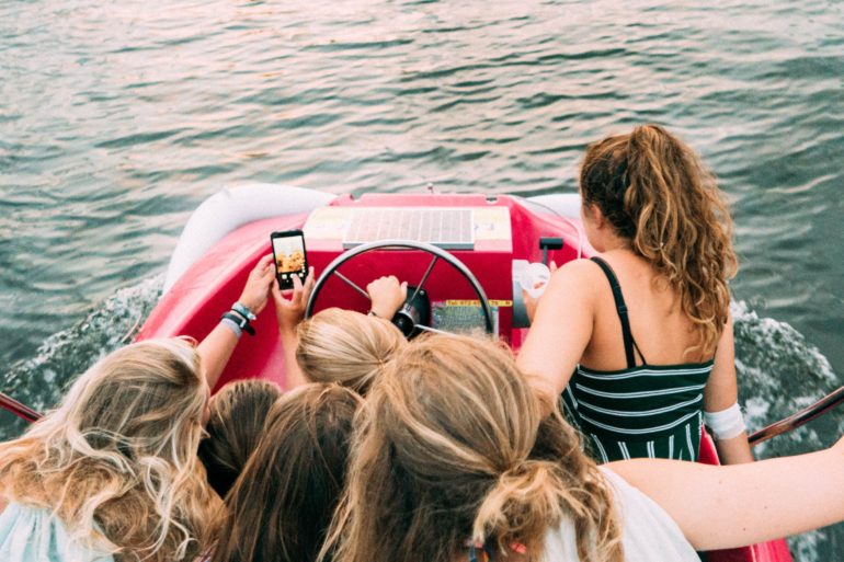 teen girls on boat taking a selfie together