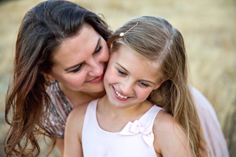 girl standing smiling with mom