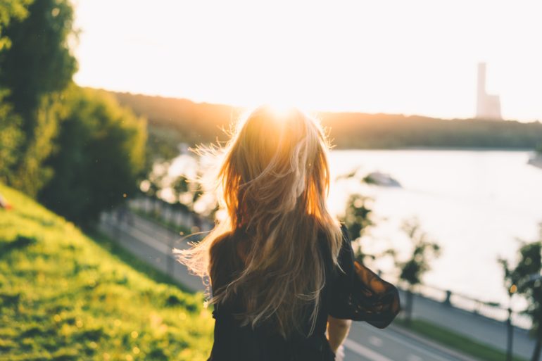 girl facing away looking at sunset